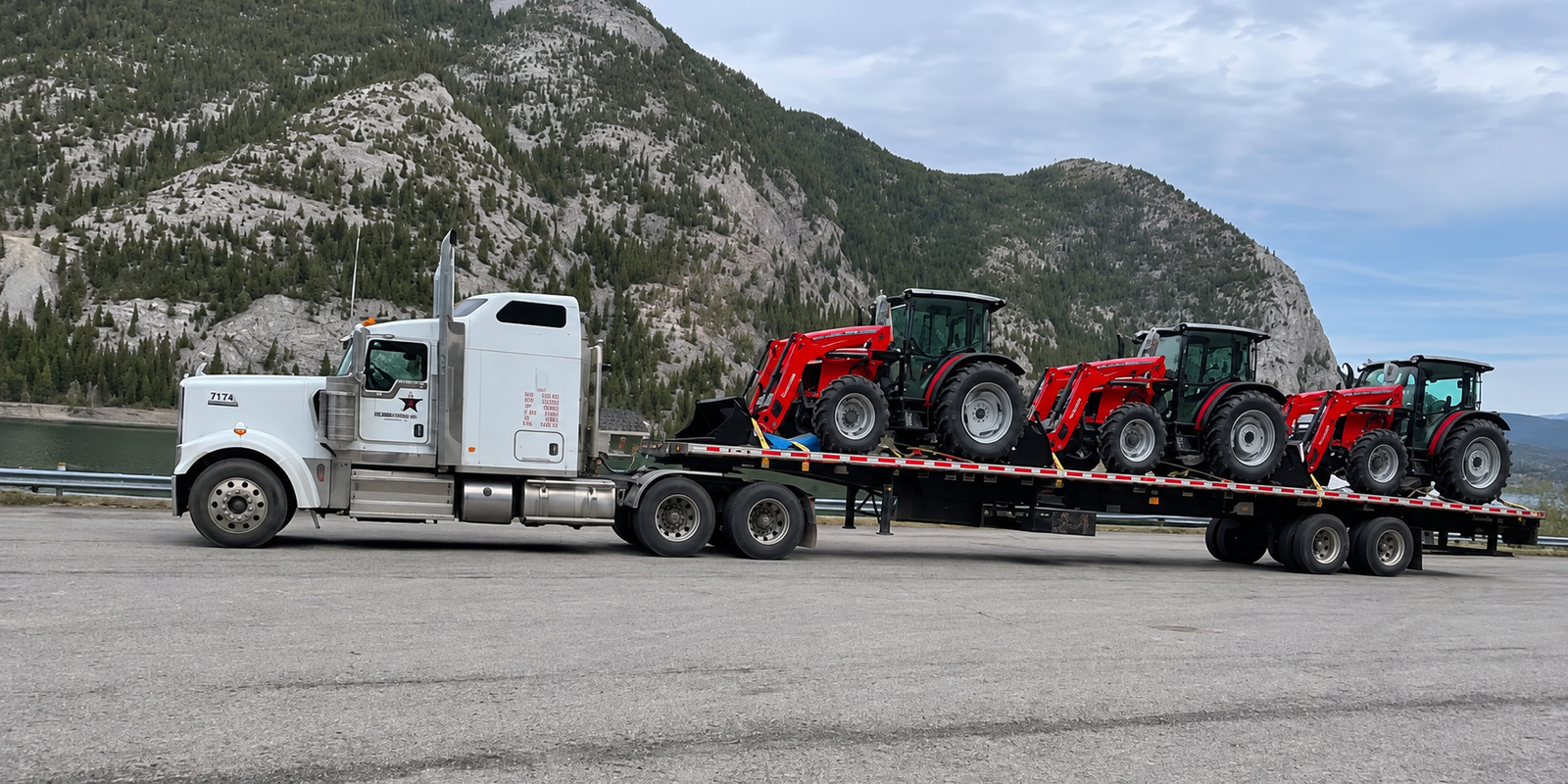 Lubana Trucking heavy haul transportation service moving farm equipment and tractors across Canada using specialized flatbed trailers.
